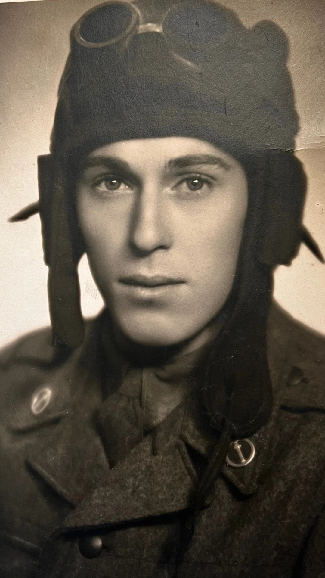 Historická černobílá fotografie muže v letecké helmě a brýlích